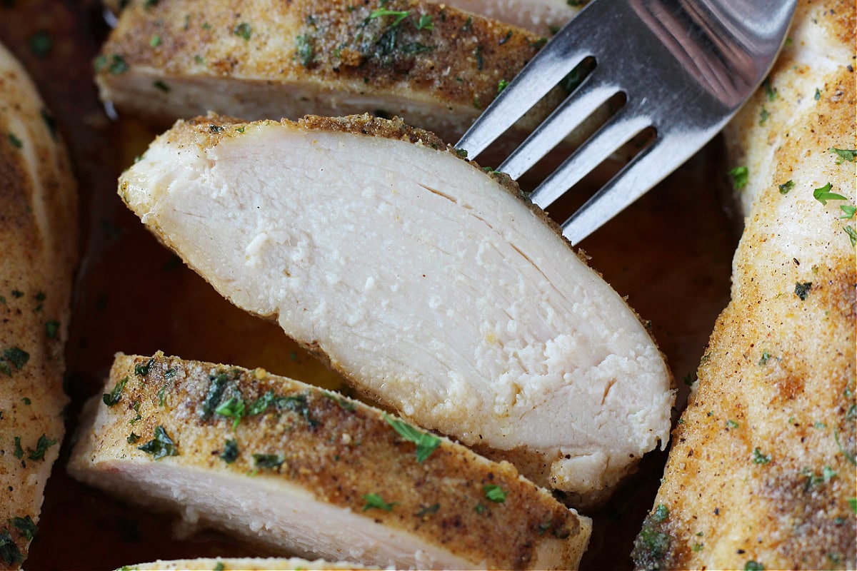 A sliced chicken breast on a fork.