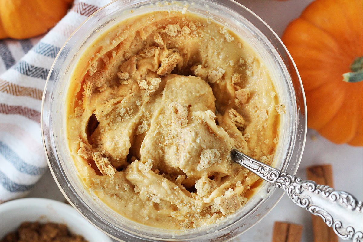 A vintage spoon in a Ninja Creami pint of pumpkin pie ice cream with graham crackers.
