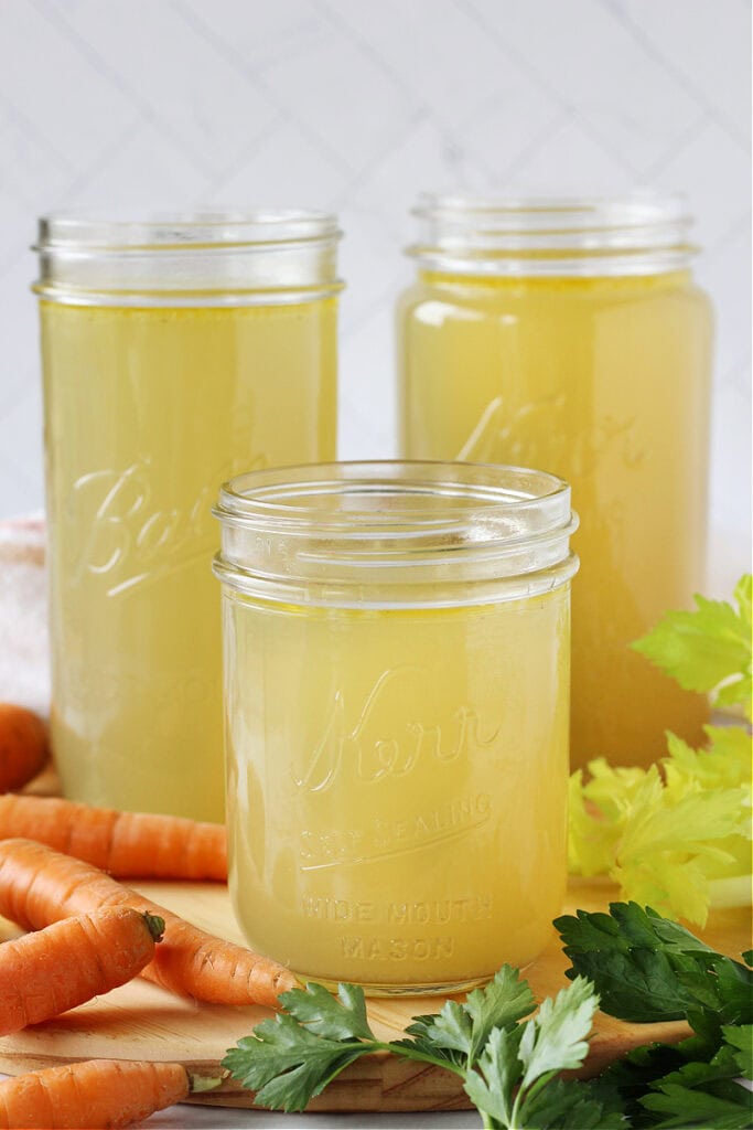 Three mason jars filled with homemade chicken broth.