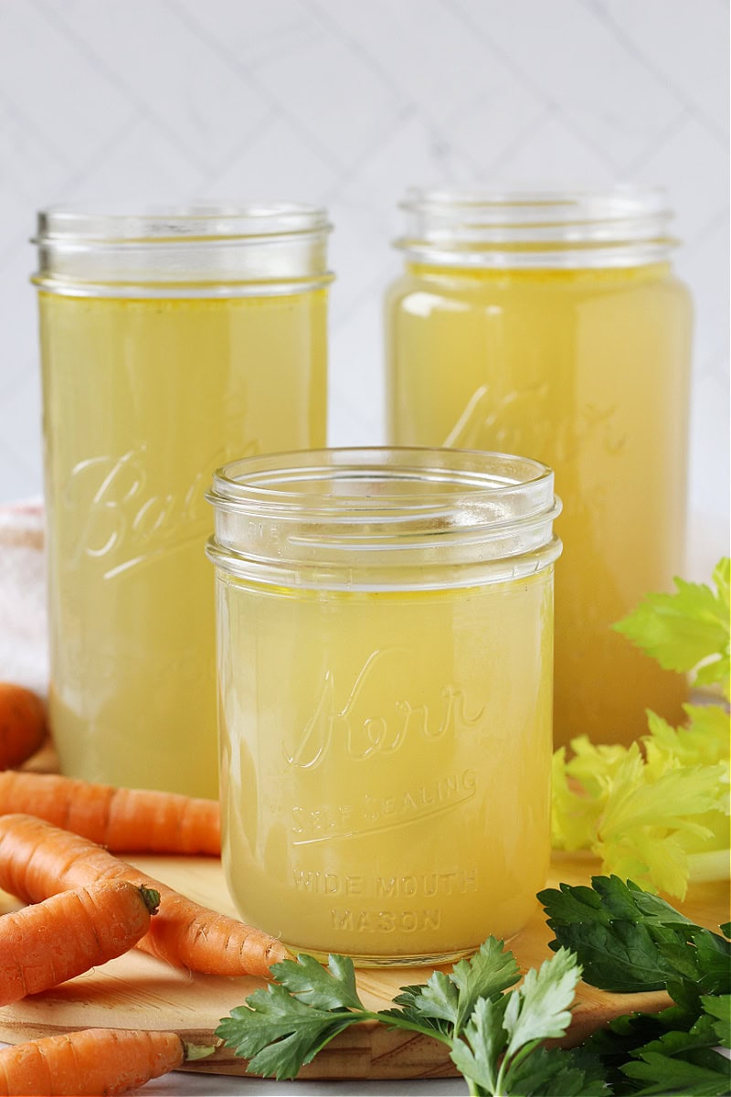 Three mason jars filled with homemade chicken broth.