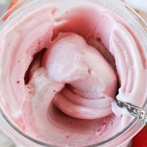 Vintage spoon in a Ninja Creami pint filled with strawberry ice cream.
