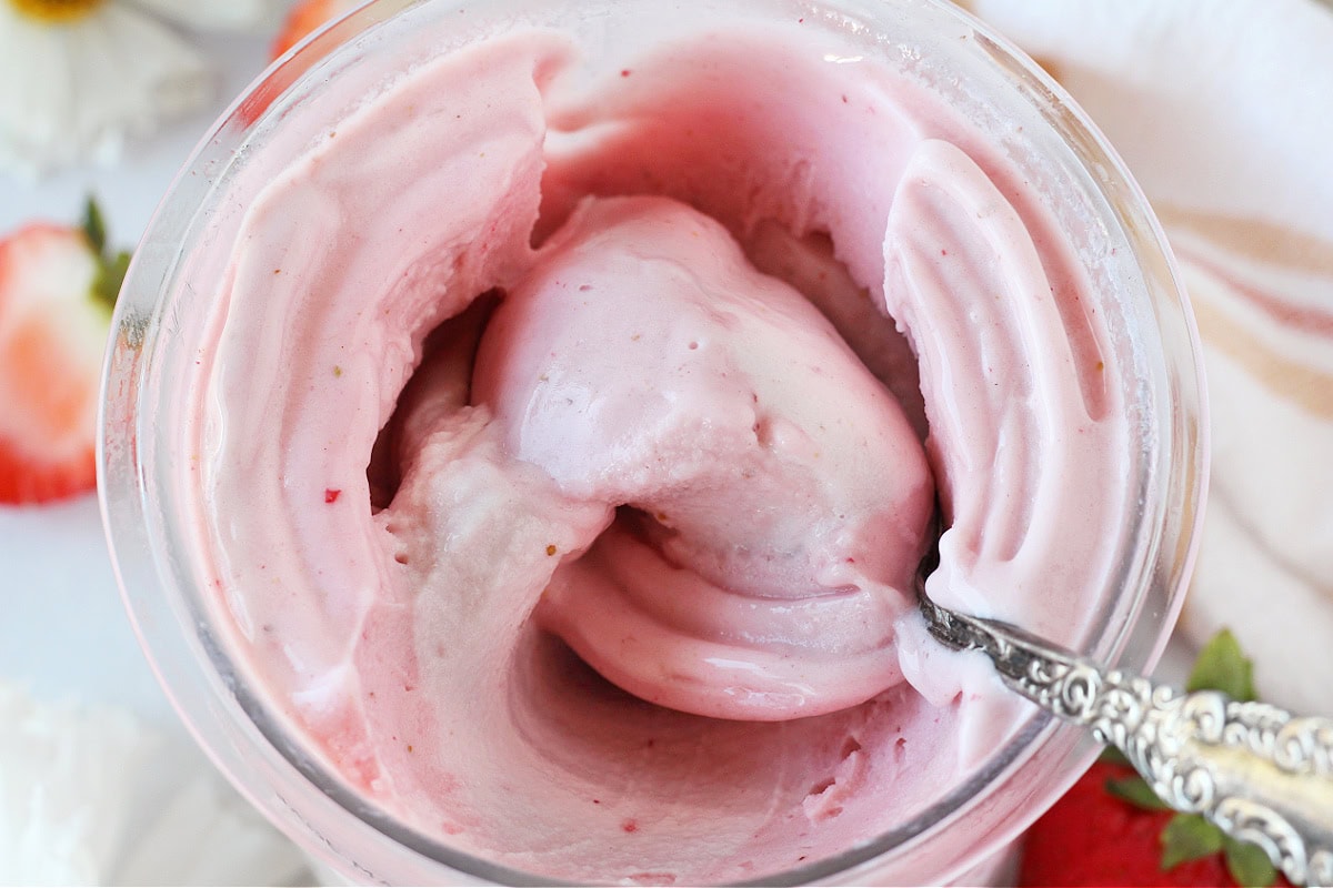 Vintage spoon in a Ninja Creami pint filled with strawberry ice cream.