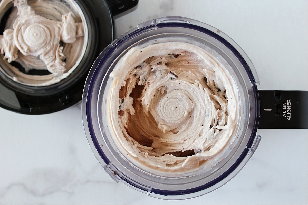 Pieces of Oreo cookies in cookies and cream ice cream in Ninja pint.