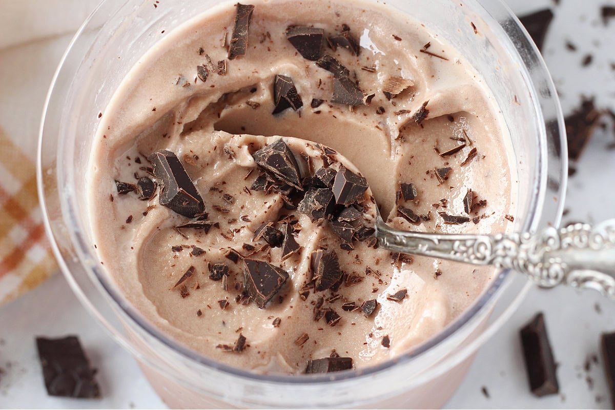 Chocolate chunks on top of Ninja Creami chocolate ice cream with spoon.