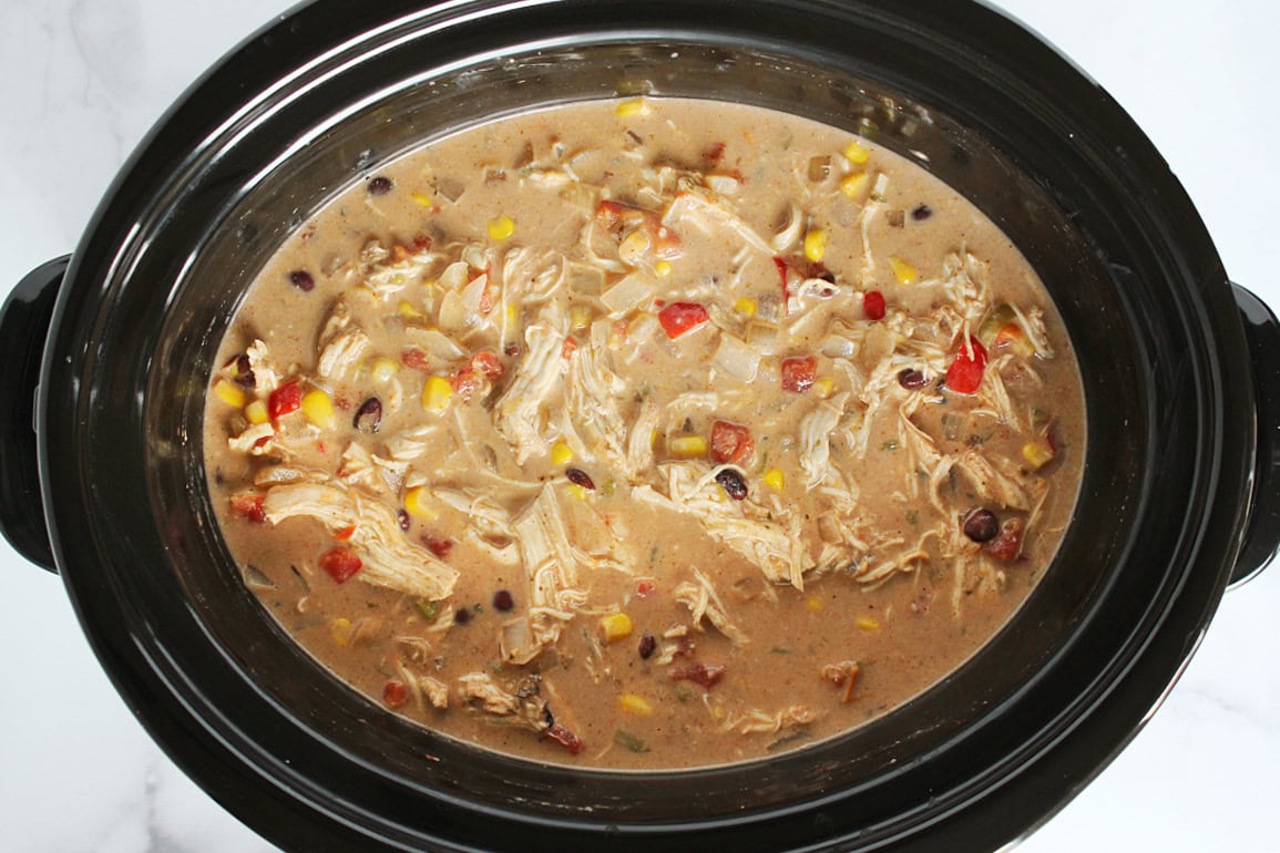 Crack chicken chili in a black slow cooker.