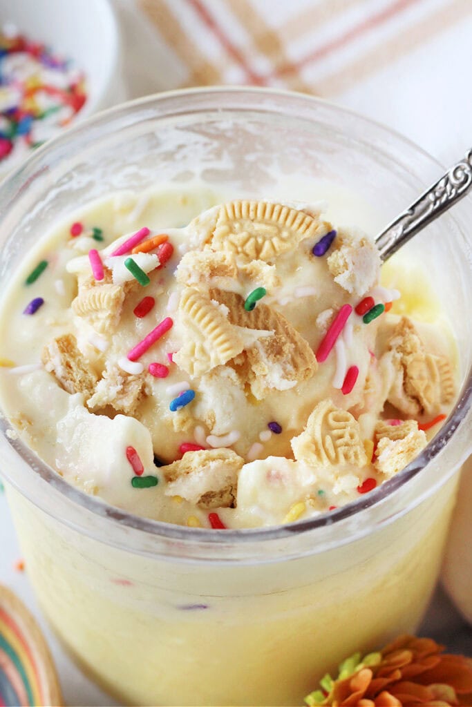 Vintage spoon in cake batter ice topped with sprinkles and golden Oreos.