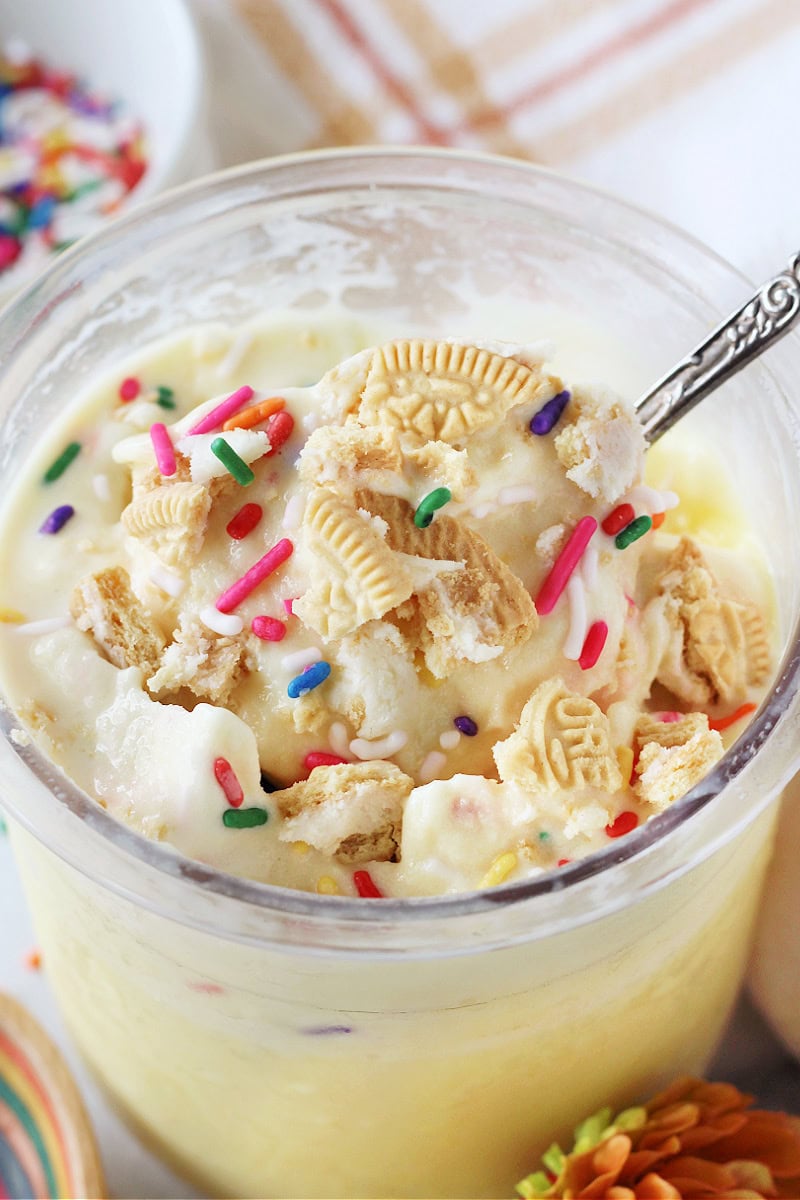Vintage spoon in cake batter ice topped with sprinkles and golden Oreos.