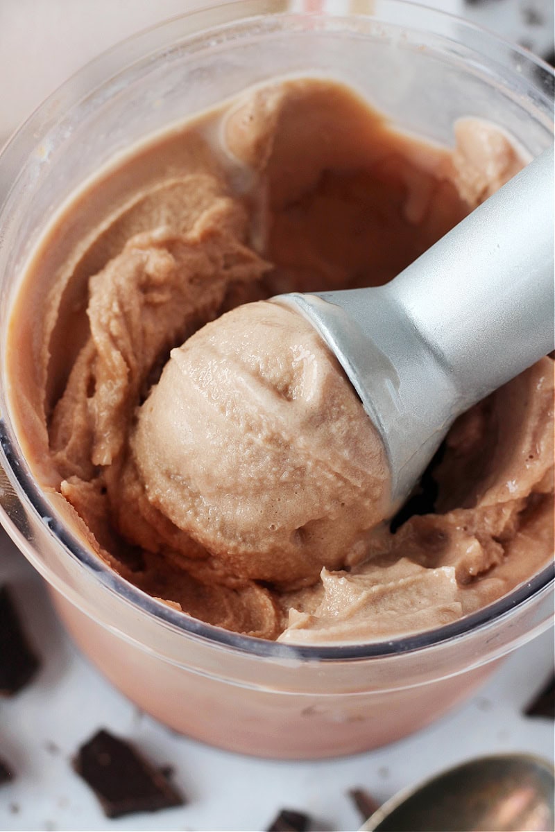 Ice cream scoop in homemade chocolate ice cream in Creami pint.