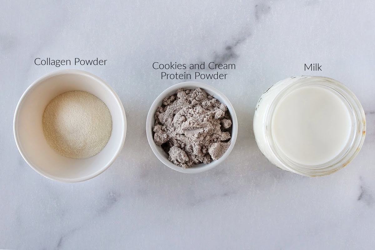 Labeled ingredients for Ninja Creami Cookies and Cream ice cream on a white marble countertop.