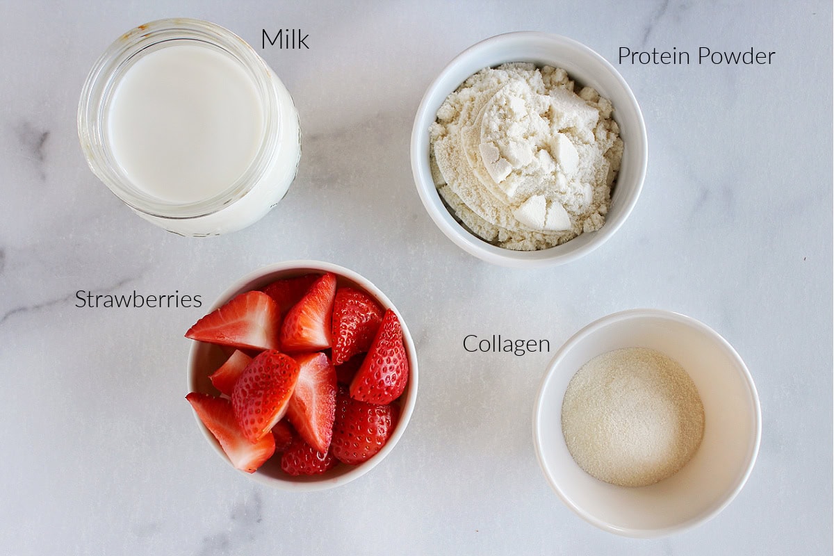 Labeled ingredients for Ninja Creami strawberry ice cream on a white marble countertop.