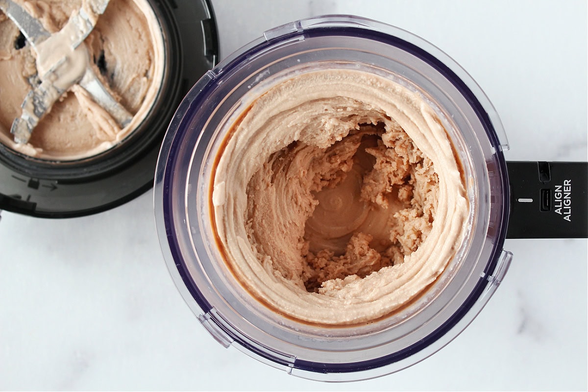 Chocolate ice cream in Ninja Creami outer bowl with blender lid.