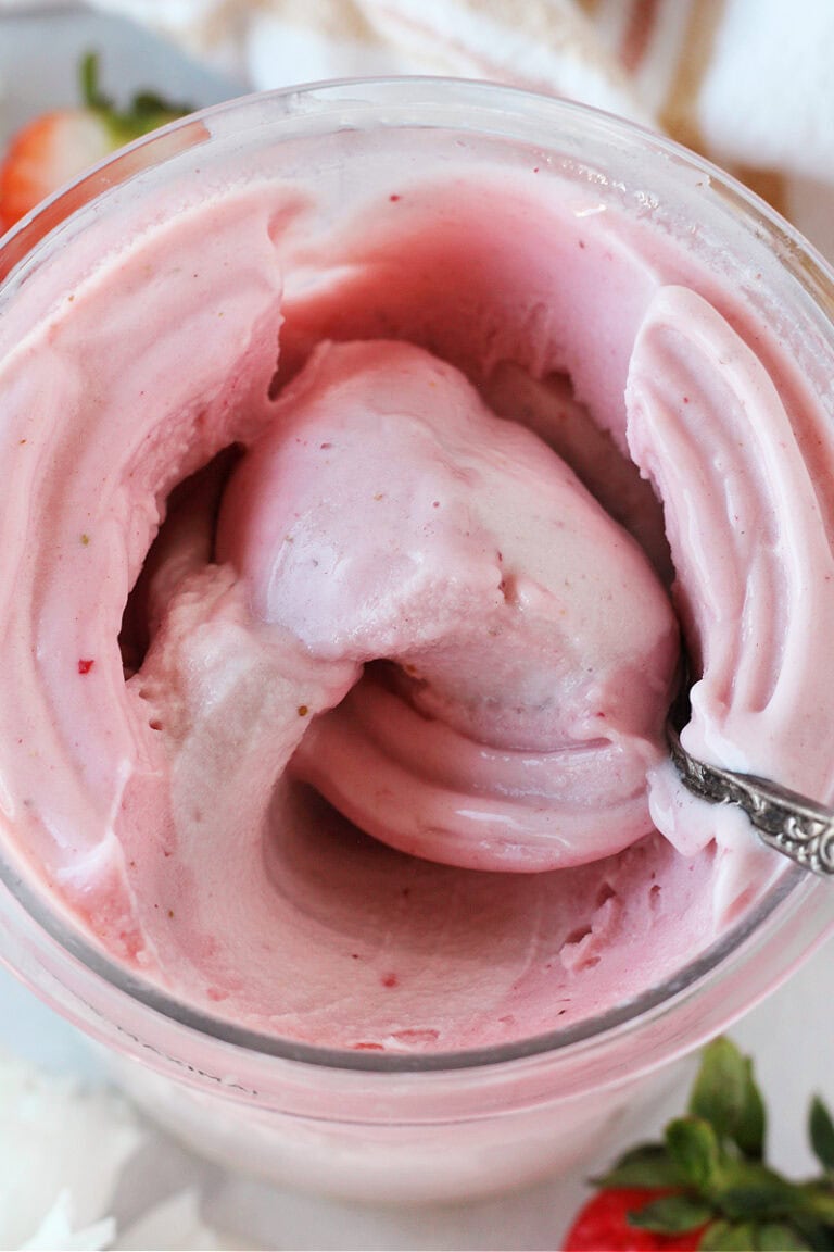 Strawberry ice cream with a spoon in a Ninja Creami pint.
