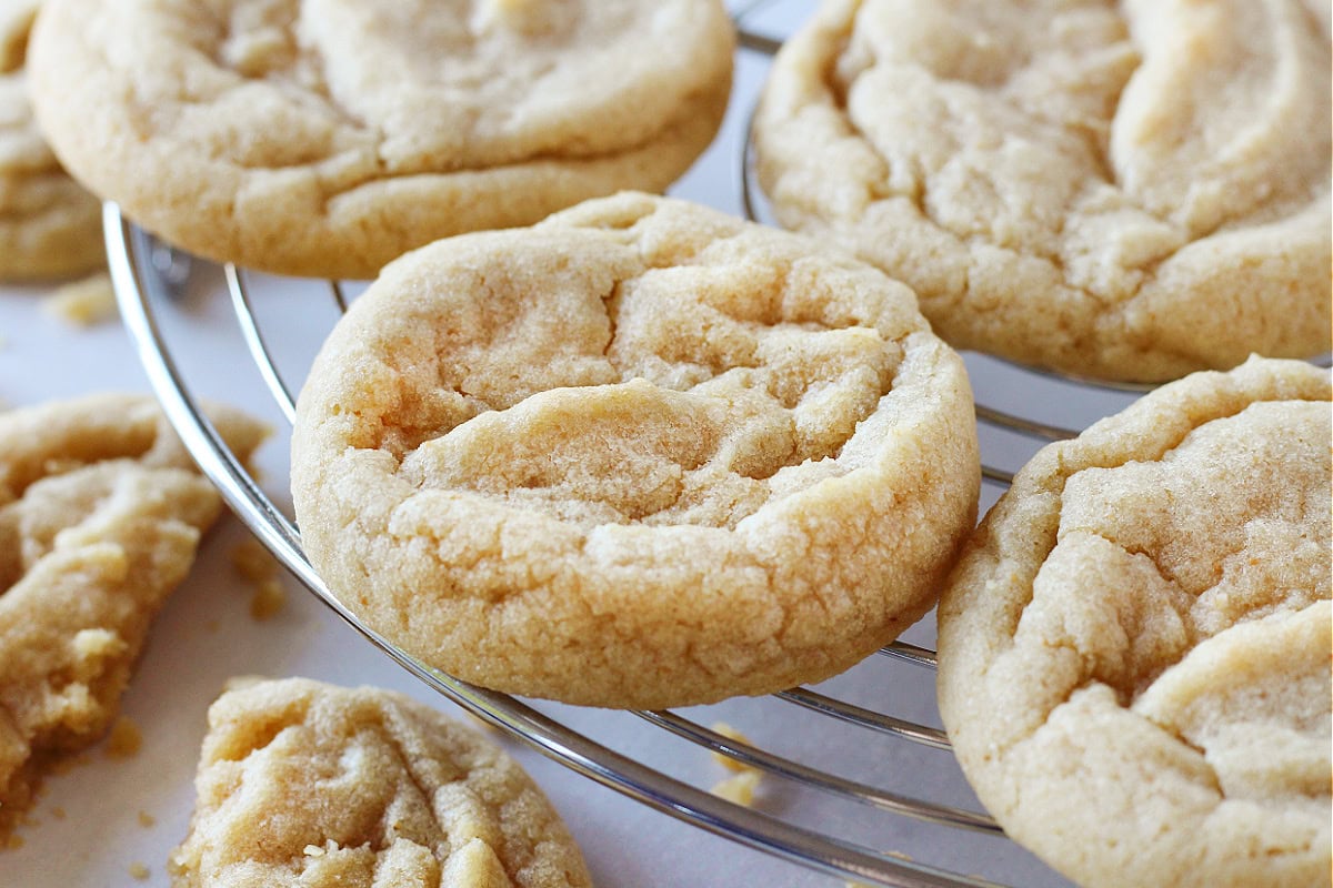 Brown butter cookies on a round metal cooling rack.