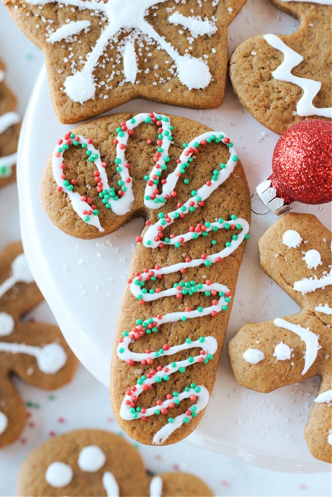 A homemade gingerbread cookie decorated with white frosting and holiday sprinkles.