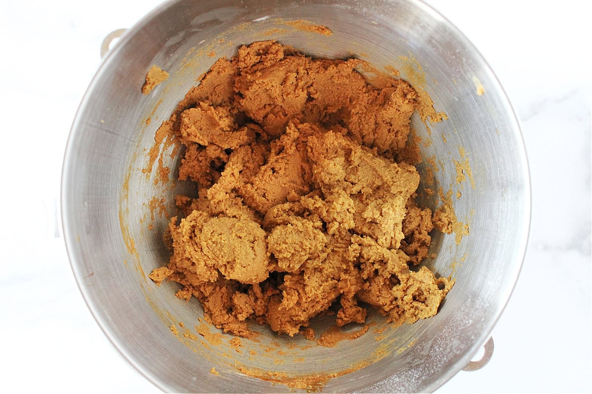 Gingerbread cookie dough in the bowl of a stand mixer.