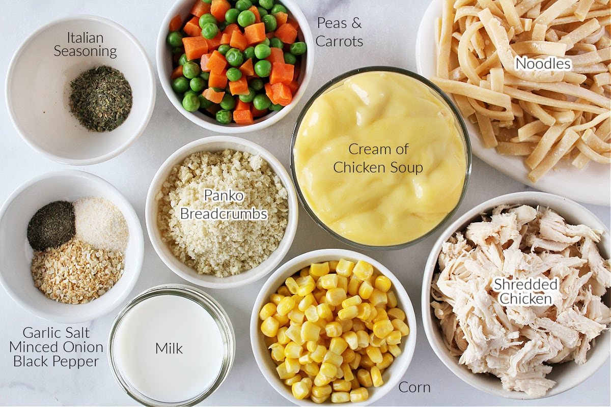 Labeled ingredients for easy chicken noodle casserole on a white marble countertop.