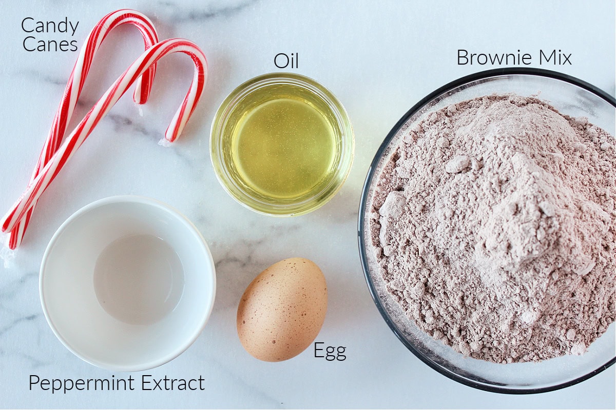 Labeled ingredients for peppermint brownie cookies on a white marble countertop.