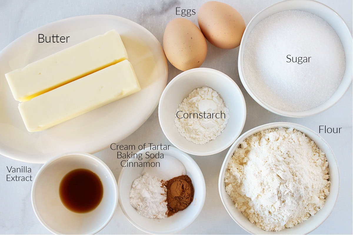 Labeled ingredients for snickerdoodle cookies on a white marble countertop.