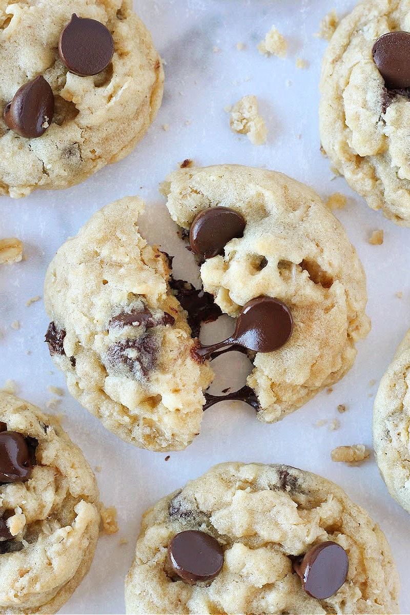 An oatmeal chocolate chip cookie broke in half with melted chocolate between the halves.