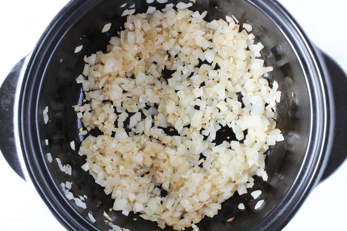 Sauteed diced onion and minced garlic in a black Dutch oven.