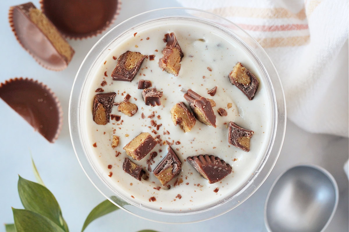 Chopped Reese's peanut butter cups on top of homemade protein ice cream.