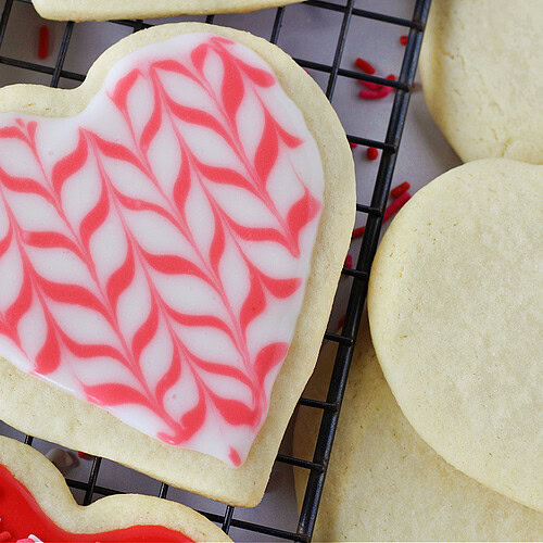 Pink and white icing on a heart-shaped sugar cookie.