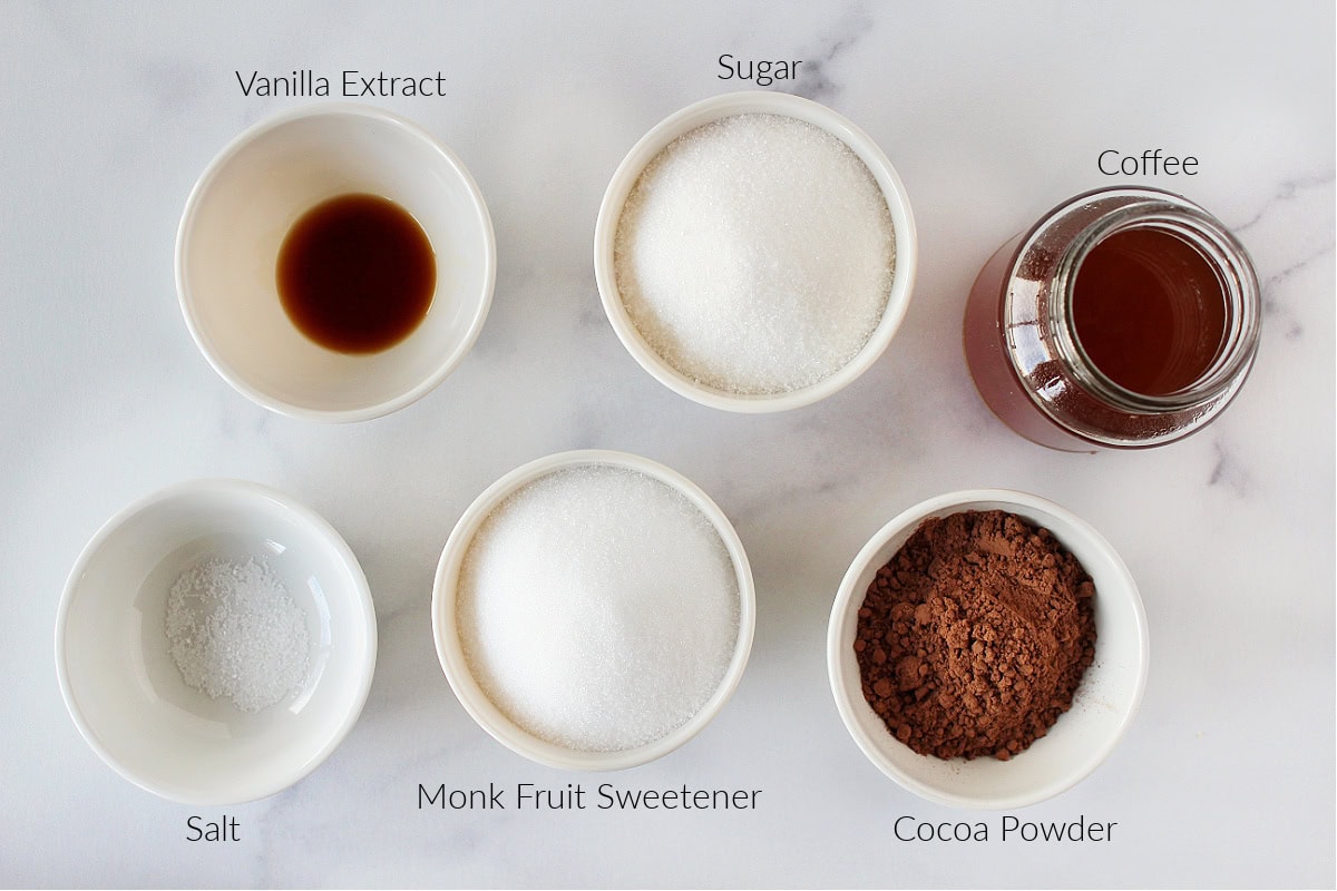 Labeled ingredients for mocha coffee syrup on a white marble countertop.