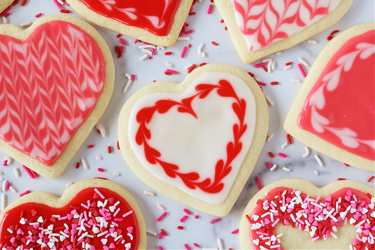 Decorated Valentine sugar cookies topped with royal icing in white, pink, and red.