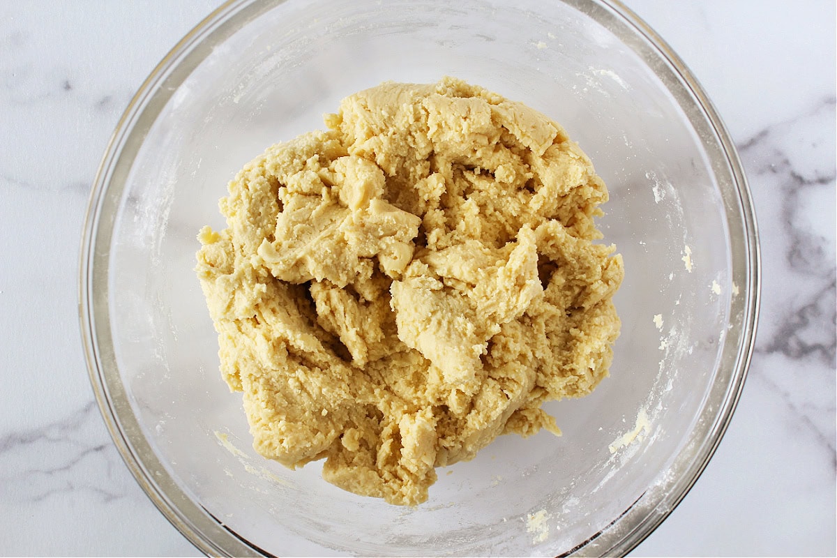 Sugar cookie dough for cutout cookies in a glass mixing bowl.