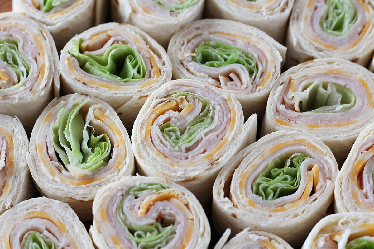 Turkey, cheese, and lettuce in a flour tortilla cut into roll ups.