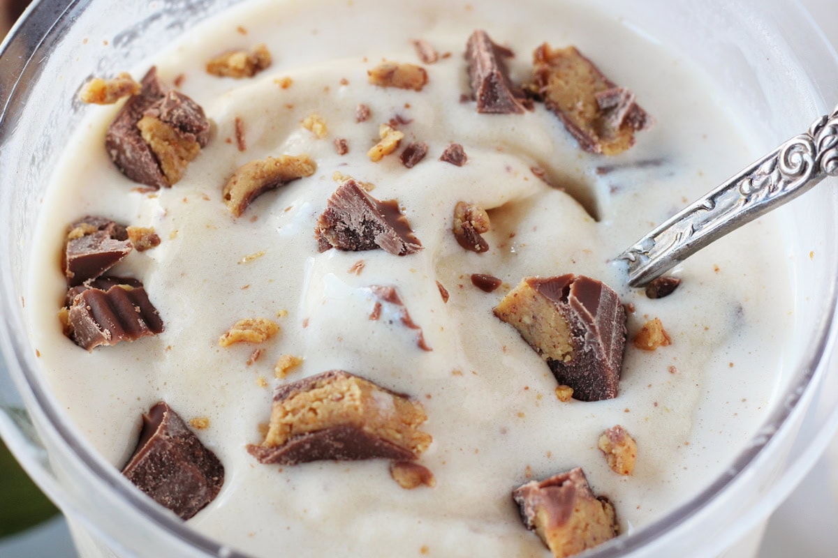 A vintage spoon digging into a container of peanut butter cup Ninja Creami ice cream.