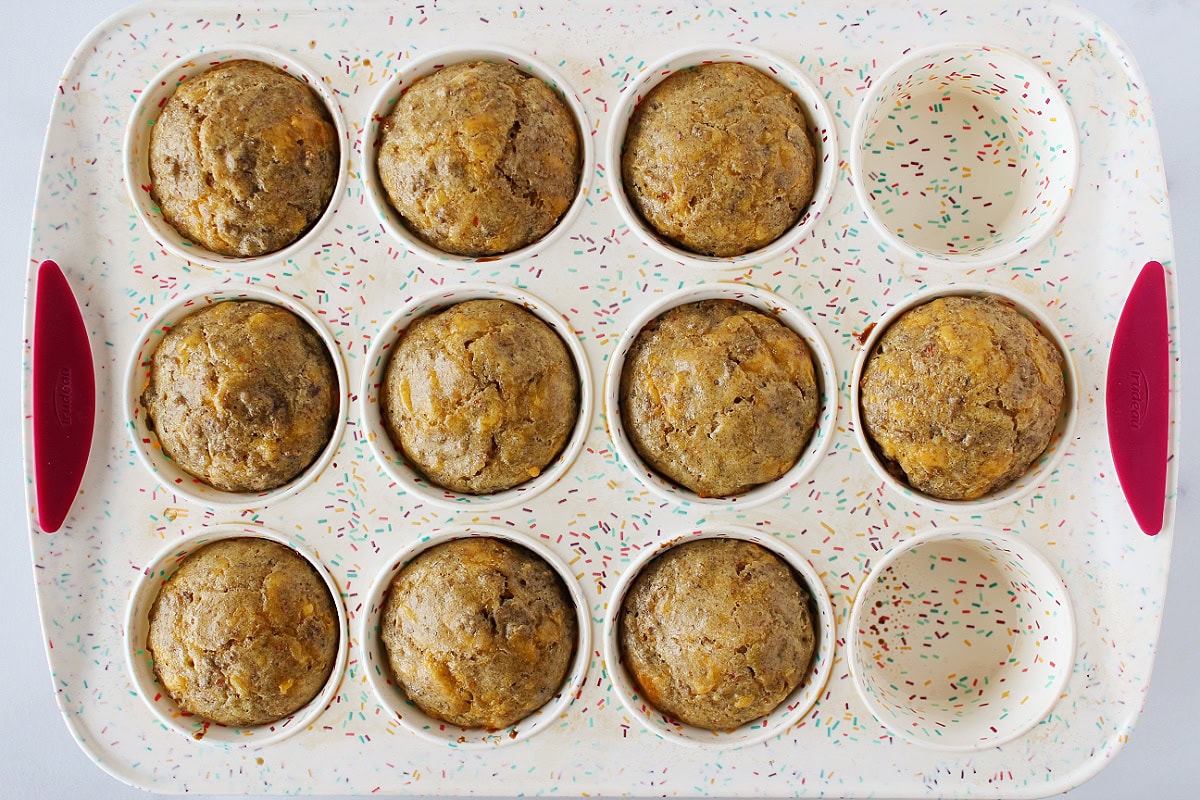 Ten baked cheesy sausage pancake mix muffins in a silicone pan.