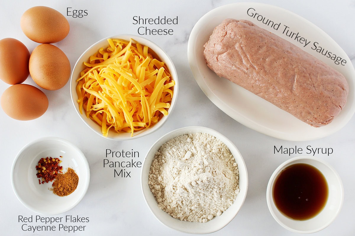 Labeled ingredients for sausage pancake mix muffins on a white marble countertop.