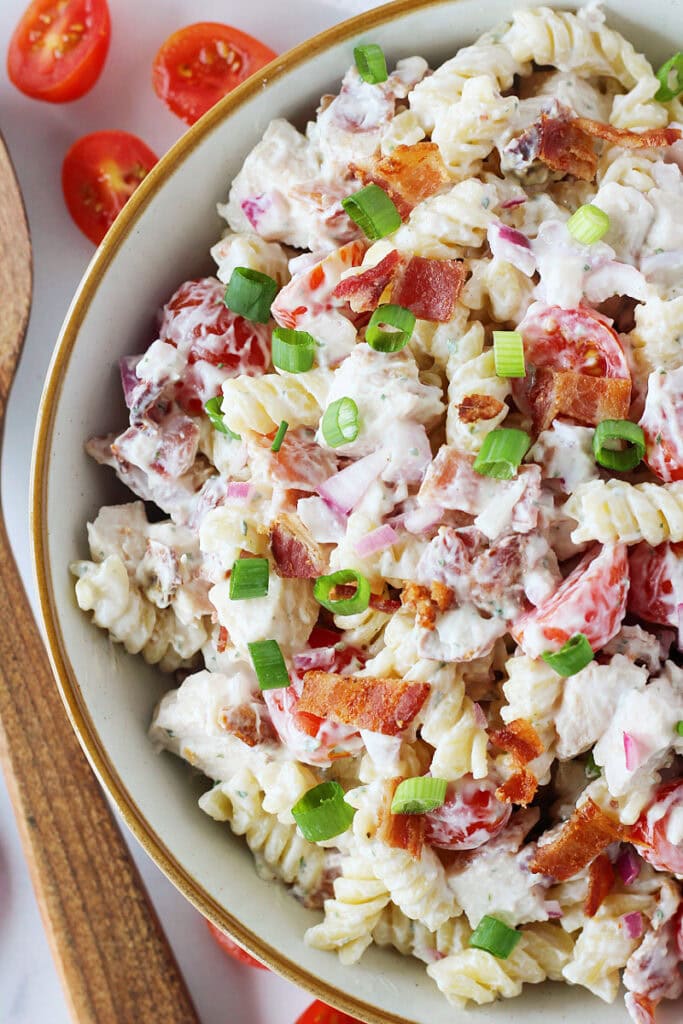 Sliced green onions on top of creamy chicken bacon and ranch pasta salad.