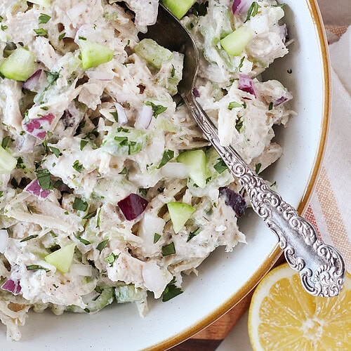 A vintage spoon in a bowl of tzatziki chicken salad.