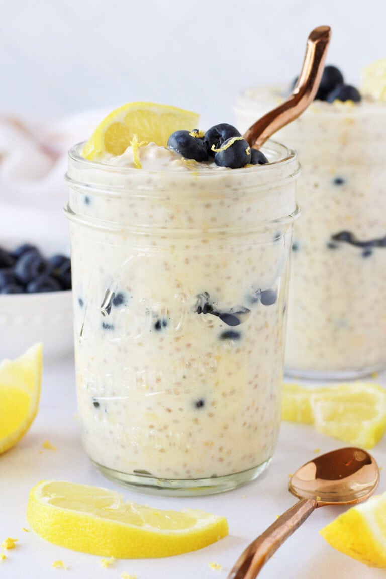 Copper spoon in jar of lemon blueberry overnight oats in a glass mason jar.