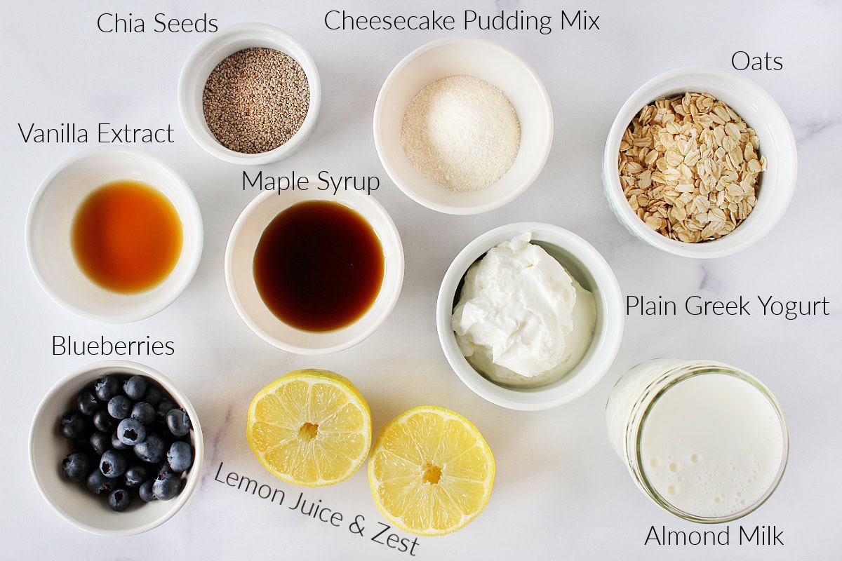 Labeled ingredients for lemon blueberry overnight oats on a white marble countertop.