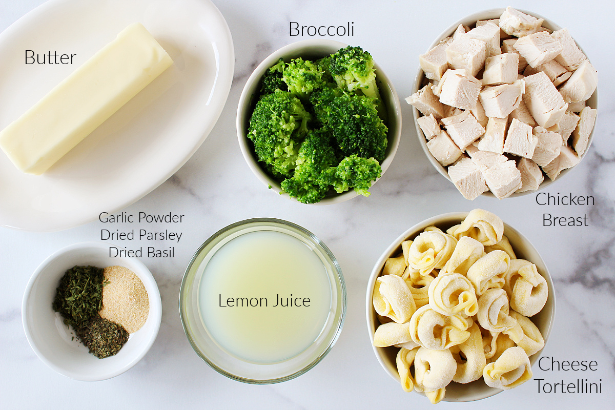 Labeled ingredients for chicken tortellini with broccoli on a white marble countertop.